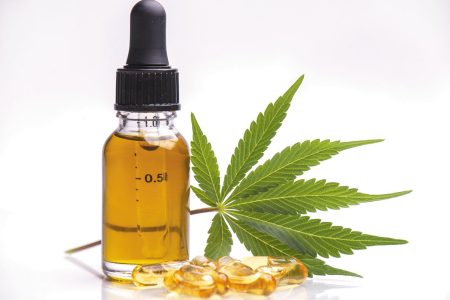 Assorted medical cannabis products with leaf, capsules and CBD oil isolated over white background